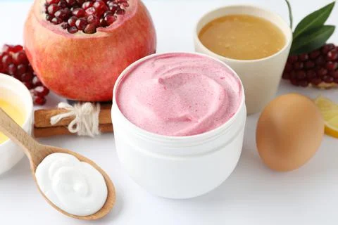 Jar of facial mask, pomegranate and fresh ingredients on white background. Na Stock Photos