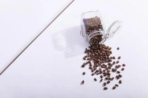 A jar of fresh fragrant coffee beans, on a white background. Hard shadow from Stock Photos