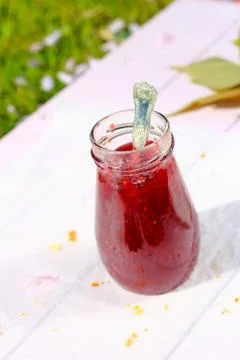 A jar of fresh raspberry jam on light rustic background, close up, in the gar Stock Photos