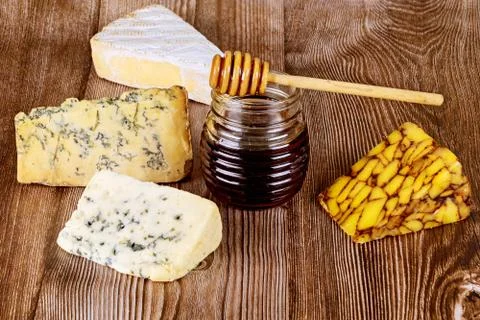 Jar of honey and different type of cheese. Stock Photos