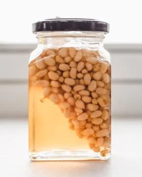 Jar of honey with pine nuts Stock Photos