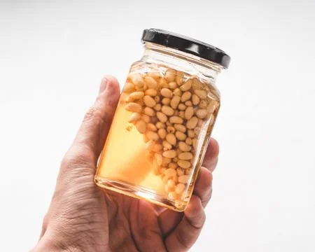 Jar of honey with pine nuts Stock Photos