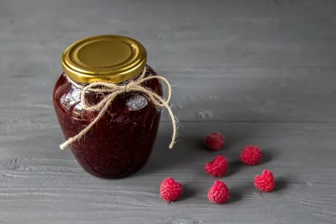 Jar of jam with fresh raspberry on the table Stock Photos