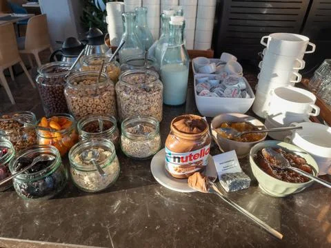 A jar of Nutella hazelnut spread sits on a hotel breakfast buffet table beside Stock Photos