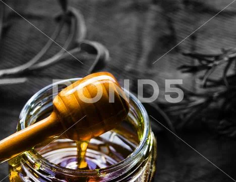Jar of organic honey and wooden dripper Stock Photos