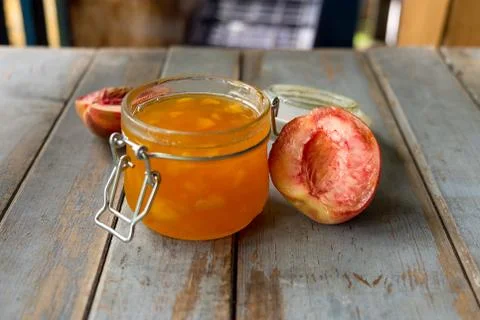 Jar with peach jam on the rustic table Stock Photos