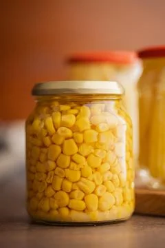 Jar Of Preserved Corn Kernels In A Glass Jar On Wooden Table Close-Up. Fotos de archivo