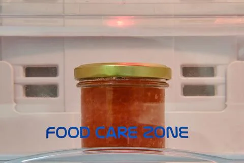 A jar of red caviar on a shelf in an empty white refrigerator Stock Photos