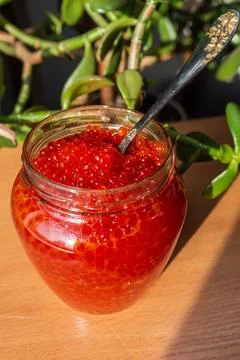 A jar of red caviar on the table Stock Photos