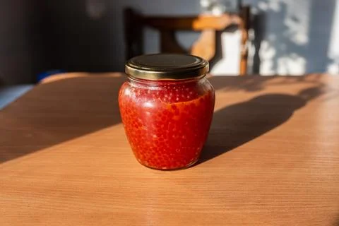 A jar of red caviar on the table Stock Photos