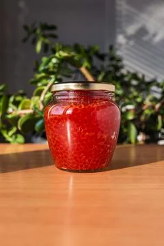 A jar of red caviar on the table Stock Photos