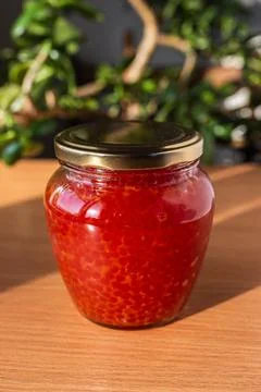 A jar of red caviar on the table Stock Photos