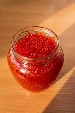 A jar of red caviar on the table Stock Photos
