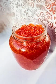 A jar of red caviar on the table Stock Photos