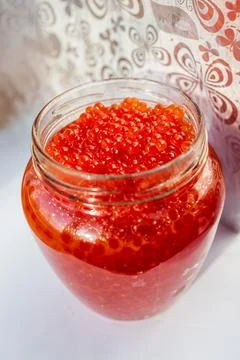 A jar of red caviar on the table Stock Photos