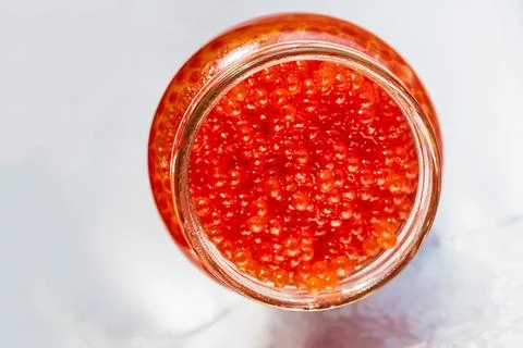 A jar of red caviar on the table Stock Photos