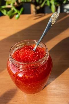 A jar of red caviar on the table Stock Photos