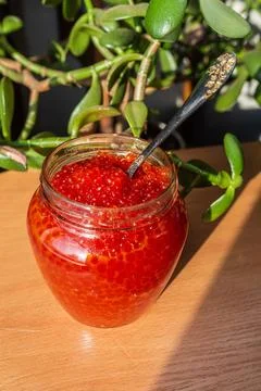 A jar of red caviar on the table Stock Photos