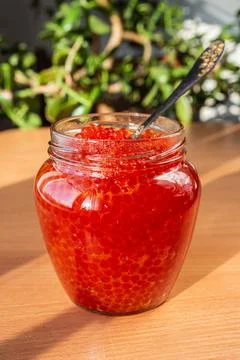 A jar of red caviar on the table Stock Photos