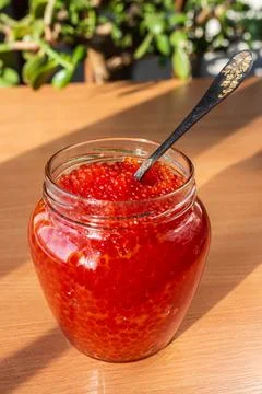 A jar of red caviar on the table Stock Photos