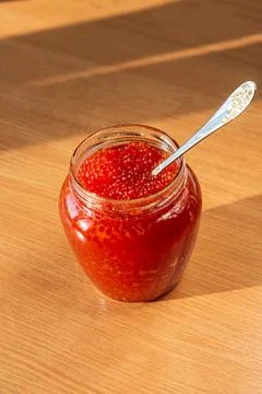 A jar of red caviar on the table Stock Photos