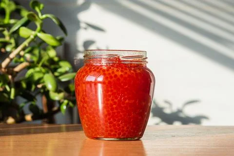A jar of red caviar on the table Stock Photos