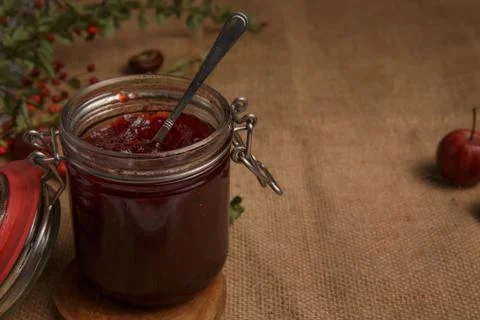 Jar of strawberry jam is on the table, covered with a rough country tablecloth Stock Photos