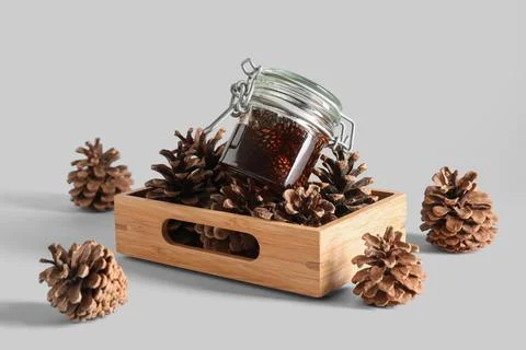 Jar of tasty pine cone jam with wooden tray on white background Stock Photos