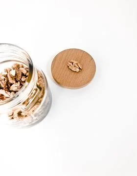 A jar of walnuts on a white table. Stock Photos