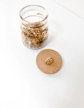 A jar of walnuts on a white table. Stock Photos