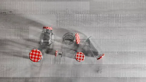 Jars of assorted sizes on a wooden table Stock Photos