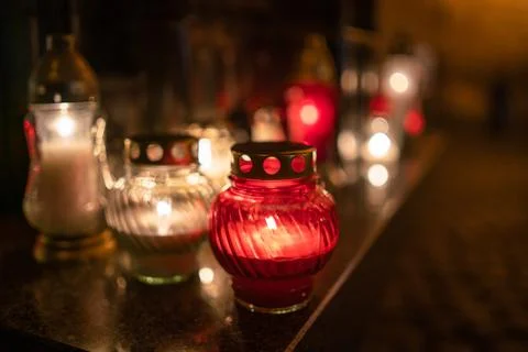 Jars with burning candles on stone surface at night Stock Photos