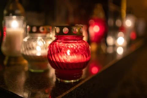Jars with burning candles on stone surface at night Stock Photos