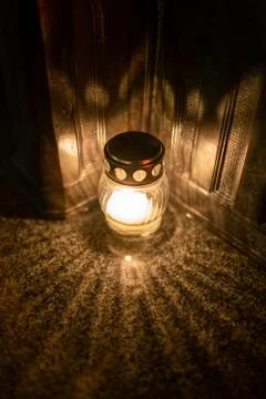 Jars with burning candles on stone surface at night Stock Photos