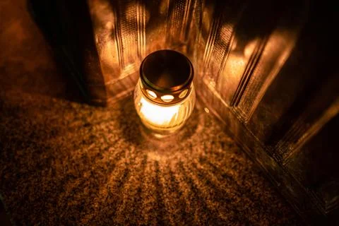 Jars with burning candles on stone surface at night Stock Photos