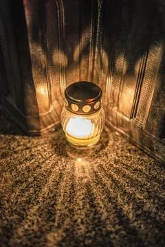 Jars with burning candles on stone surface at night Stock Photos