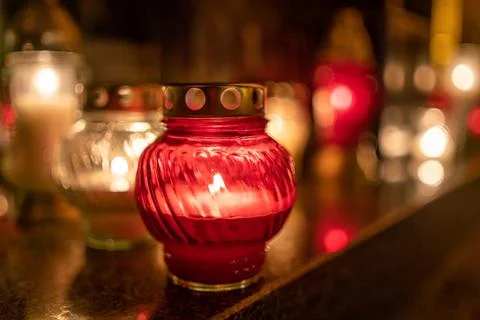 Jars with burning candles on stone surface at night Stock-Fotos