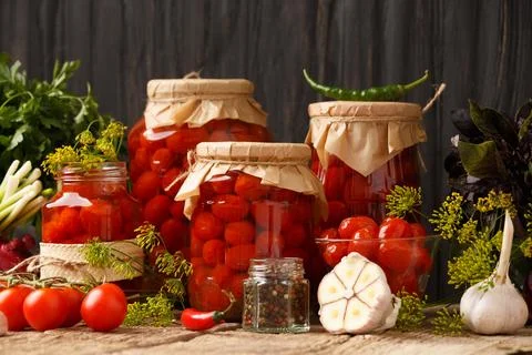 Jars with canned tomatoes on wooden background Stock Photos