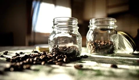 Jars with coffee beans on the table  Stock Photos