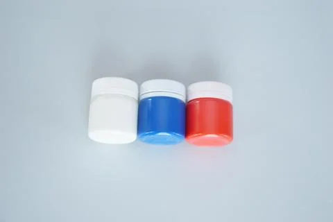 Jars with colored gouache for creativity. A set of white, blue, red paints. D Stock Photos
