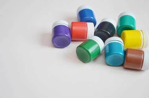 Jars with colored gouache on a light background. Paints for drawing, creativi Stock Photos