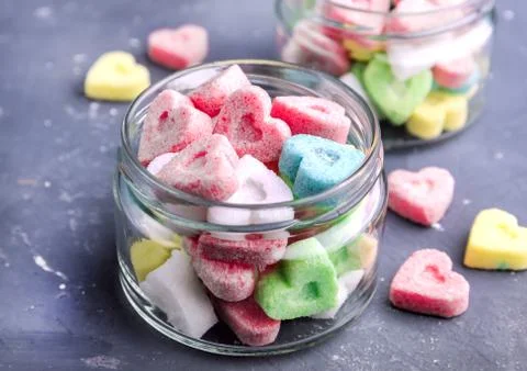 Jars with colored sugar in shape of heart Stock Photos