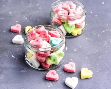Jars with colored sugar in shape of heart Stock Photos