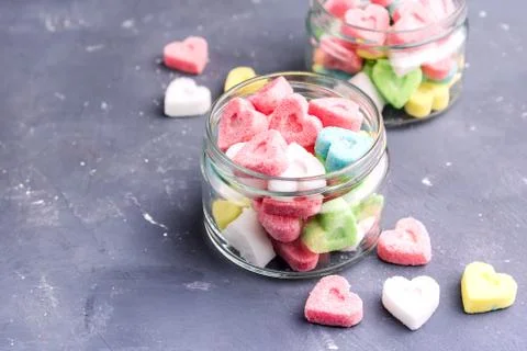 Jars with colored sugar in shape of heart Stock Photos