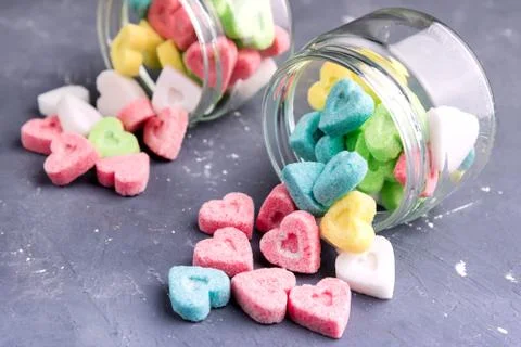 Jars with colored sugar in shape of heart Stock Photos
