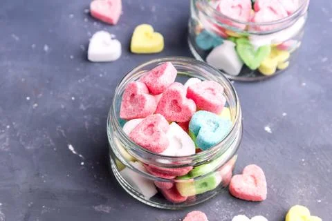 Jars with colored sugar in shape of heart Stock Photos