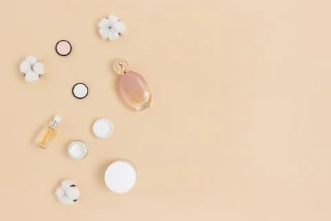 Jars with creme for face, perfume, blush and cotton flowers. Stock Photos