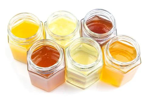 Jars with different types and colors of honey on a white background. organi.. Stock Photos