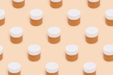 Jars of golden paint pattern on a beige background. Stock Photos