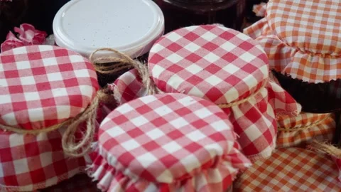 Jars of Homemade Preserves with Gingham Covers are a charming addition to a Stock Footage 284596531